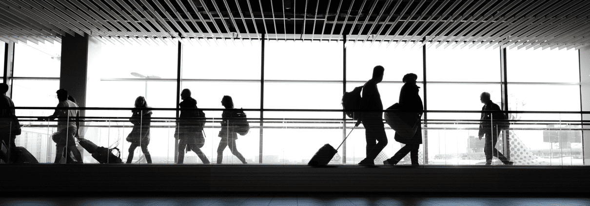Silhouettes of travellers in an airport walking