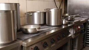 stainless steel pots on stove in commercial kitchen